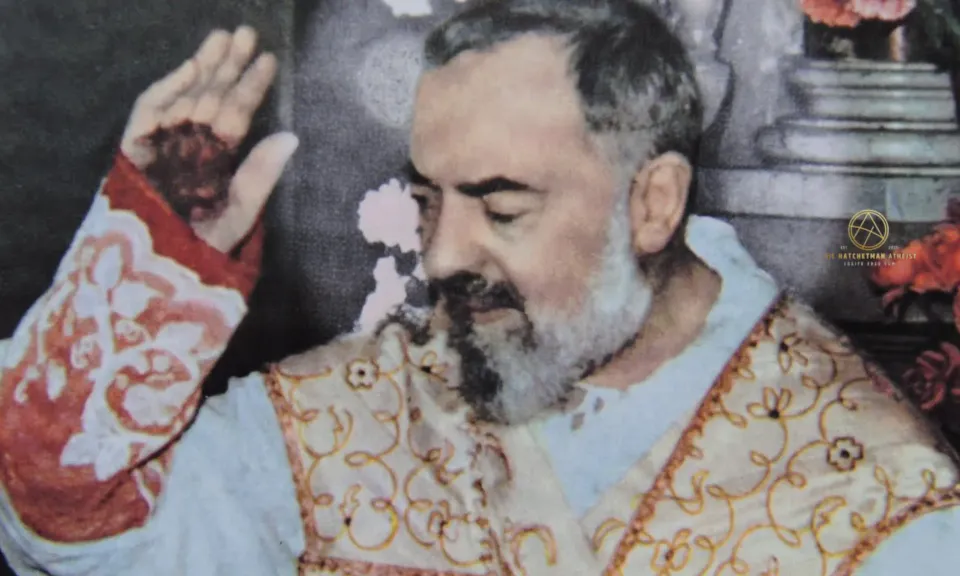 Padre Pio in ornate vestments raising his right hand, bandaged stigmata visible; colorized archival photograph.